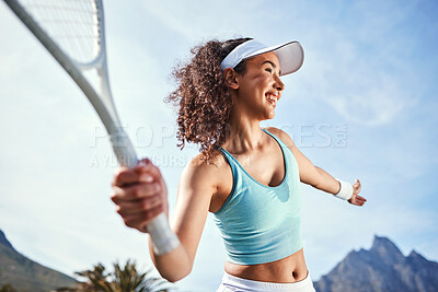 Buy stock photo Shot of an attractive young woman standing alone and getting ready to hit the ball during a game of tennis