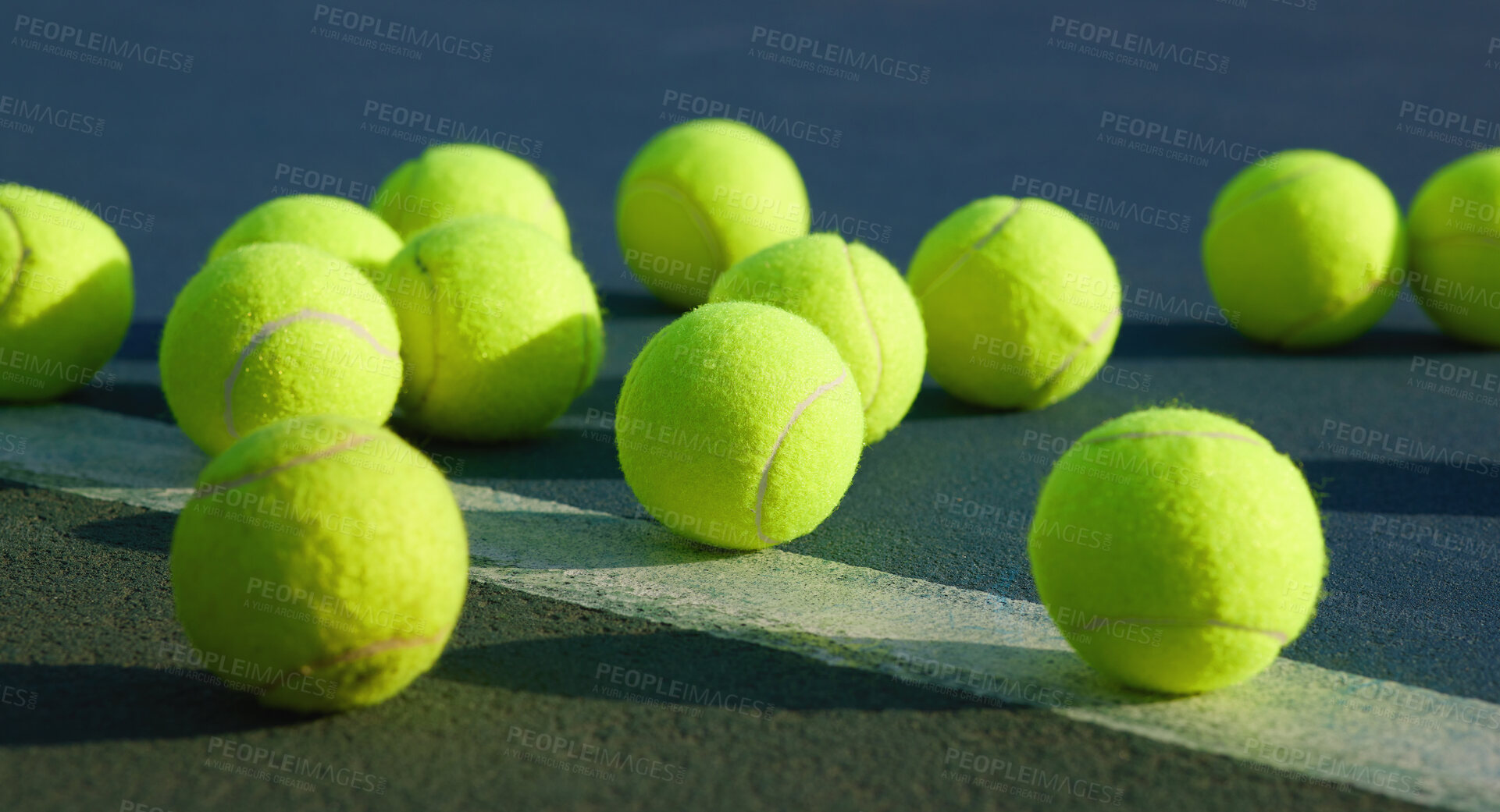 Buy stock photo Shot of an empty tennis court and tennis balls during the day