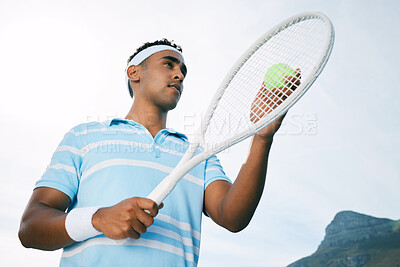 Buy stock photo Shot of a handsome young man getting ready to serve a ball during a tennis match