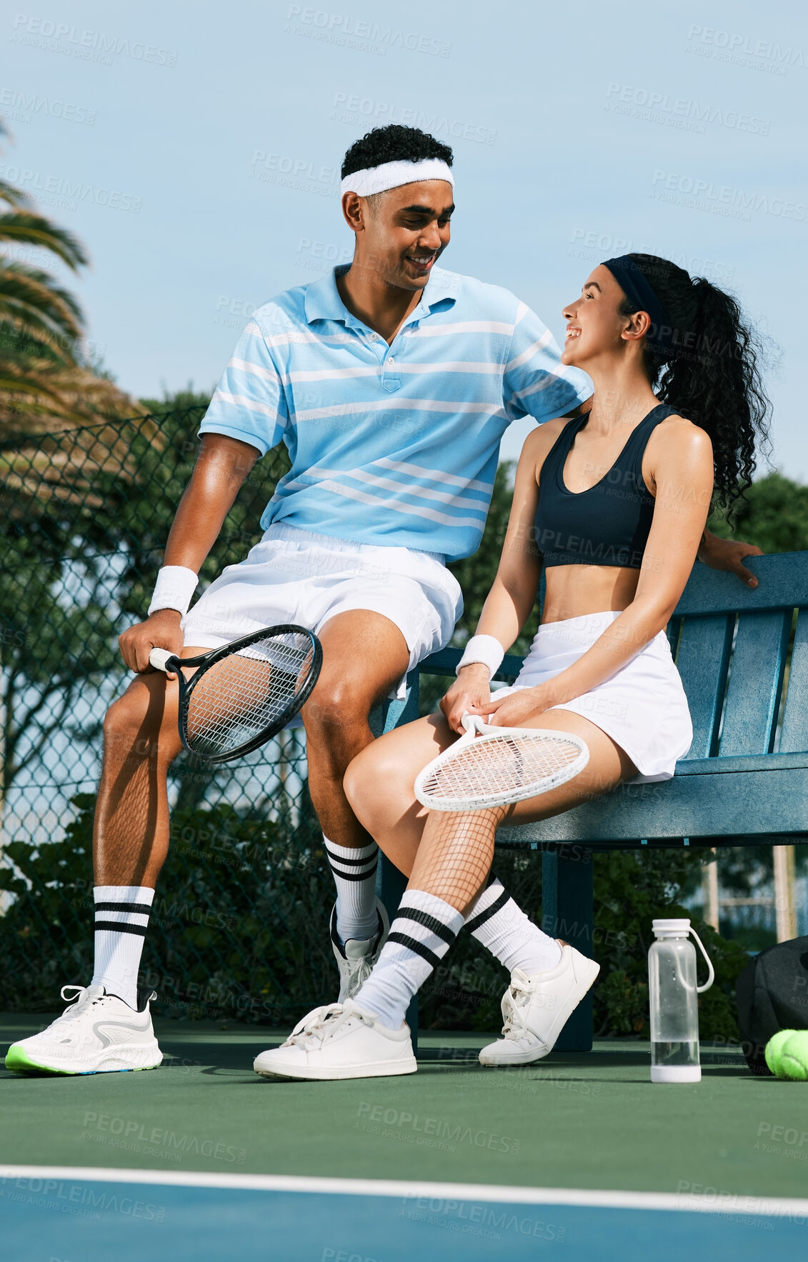 Buy stock photo Shot of two tennis players bonding while sitting together  after a match of tennis