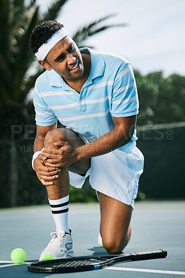 Buy stock photo Shot of a young tennis player experiencing discomfort in his knee while playing tennis