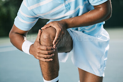 Buy stock photo Shot of a young tennis player experiencing discomfort in his knee while playing tennis