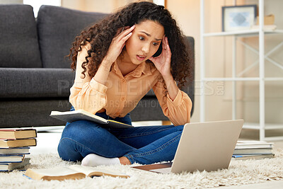 Buy stock photo Shot of a young woman looking stressed out while studying from home