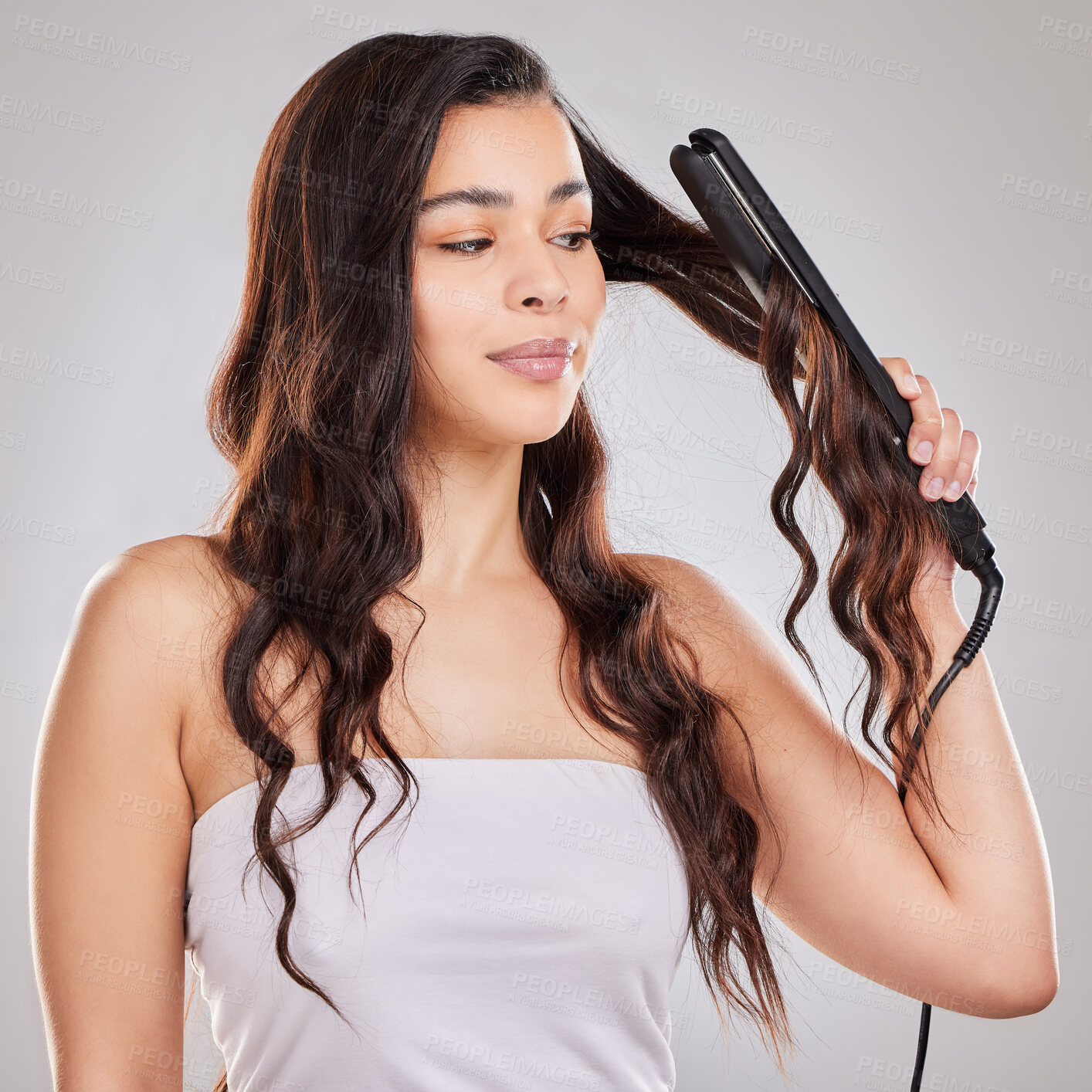 Buy stock photo Haircare, flat iron and woman with curly hair in studio for salon treatment, hairstyle or shampoo on white background. Texture, cosmetics and model for grooming, straightener and natural glow
