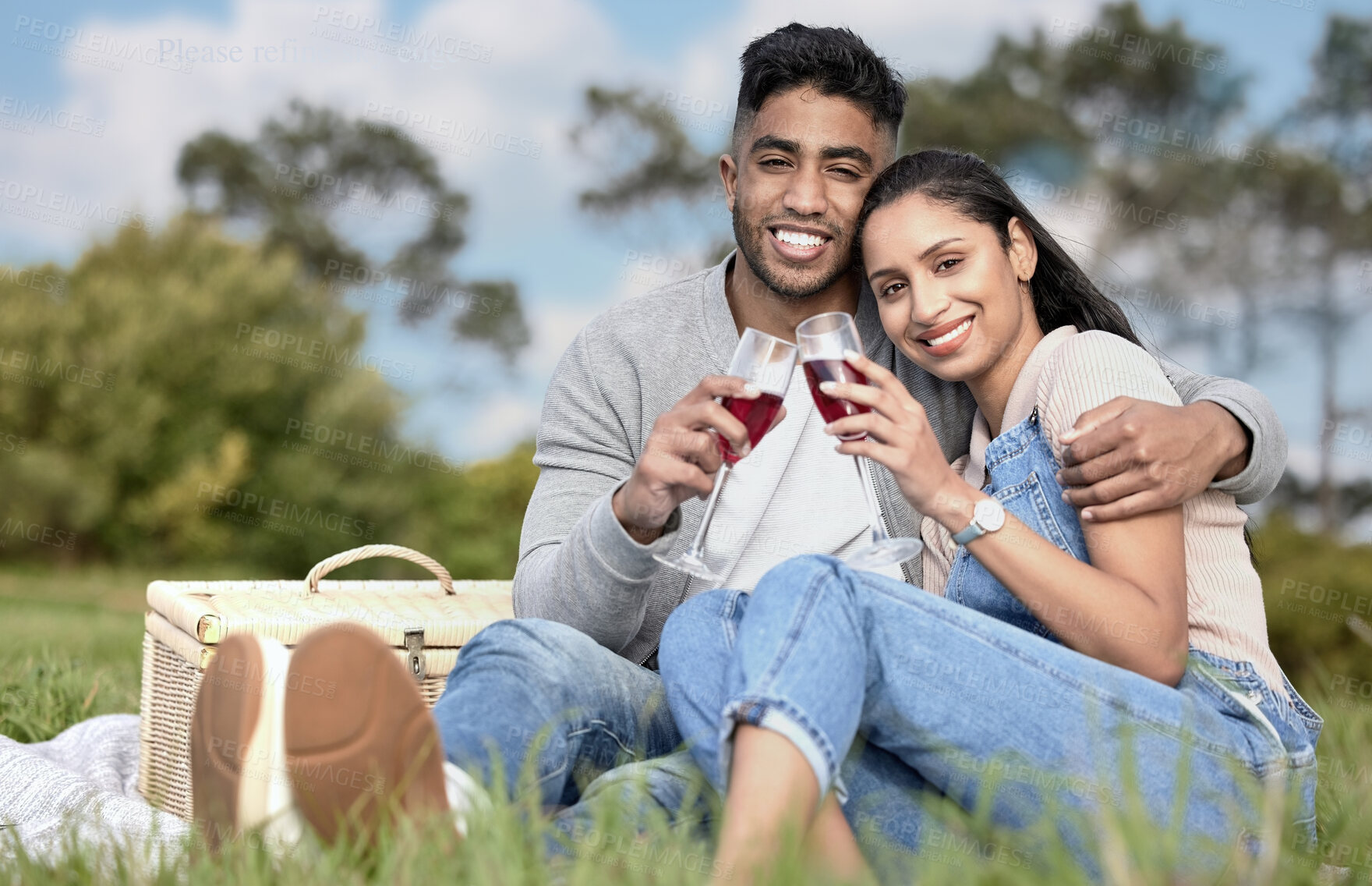 Buy stock photo Couple, toast and picnic in portrait with wine, basket and hug on grass for anniversary. Happy man, woman and together with drink in field for love, commitment and celebration in relationship
