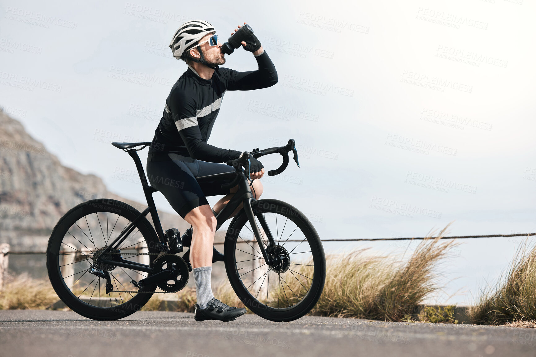 Buy stock photo Full length shot of a handsome mature man taking a water break while cycling outdoors