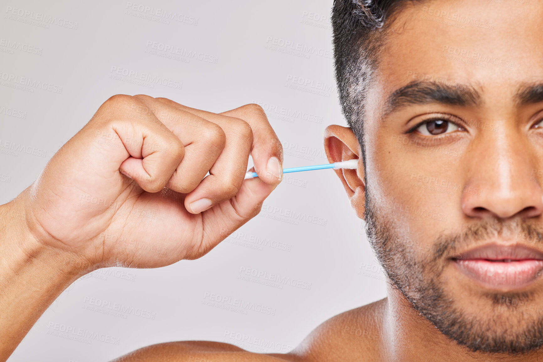 Buy stock photo Indian man, studio and portrait with cotton for cleaning ear or self care, routine for hygiene or wellness. Male person, body care and white background for wax or health, cosmetic with hygiene