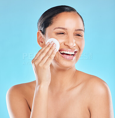 Buy stock photo Studio shot of an attractive young woman exfoliating her face against a blue background