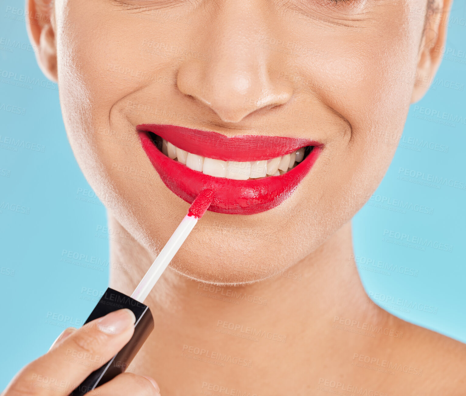 Buy stock photo Woman, mouth and apply lipstick in studio, red lips and cosmetics makeup on blue background. Female person, beauty and confident smile for glossy grooming, skin care and makeover transformation