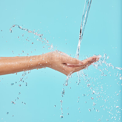 Buy stock photo Hands, water and woman in studio with natural, wellness or health routine for self care in morning. Beauty, hygiene and female person with liquid splash in palm for washing skin by blue background.