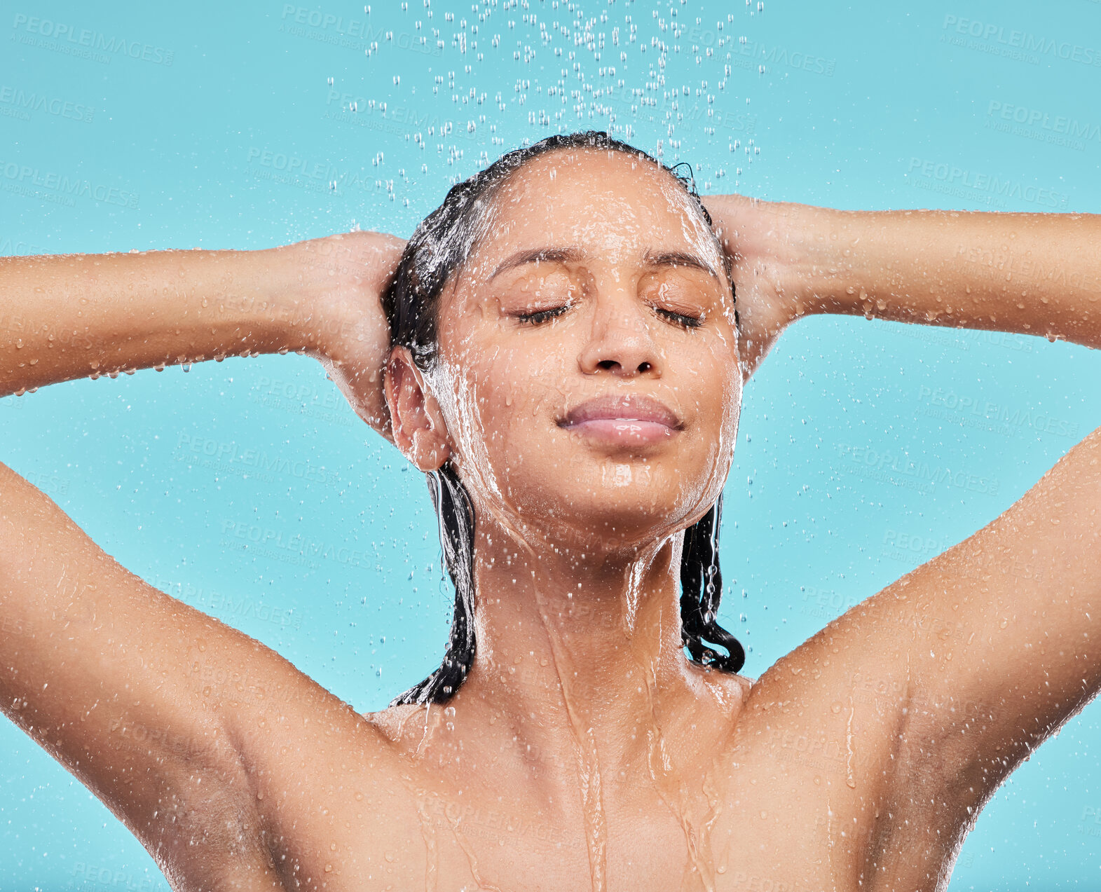 Buy stock photo Cleaning hair, shower and woman in studio for skincare, hygiene or wellness isolated on blue background. Water, face and model bath with eyes closed for dermatology, health and washing for beauty