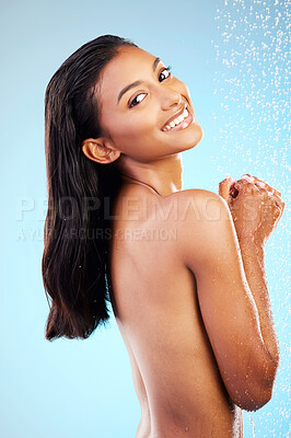 Buy stock photo Shot of a young woman taking a shower against a blue background