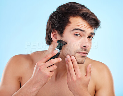 Buy stock photo Portrait, shaving and man with electric razor i studio for personal hygiene and skin care. Male person, beauty and grooming by blue background for beard, hair removal and dermatology and cosmetics