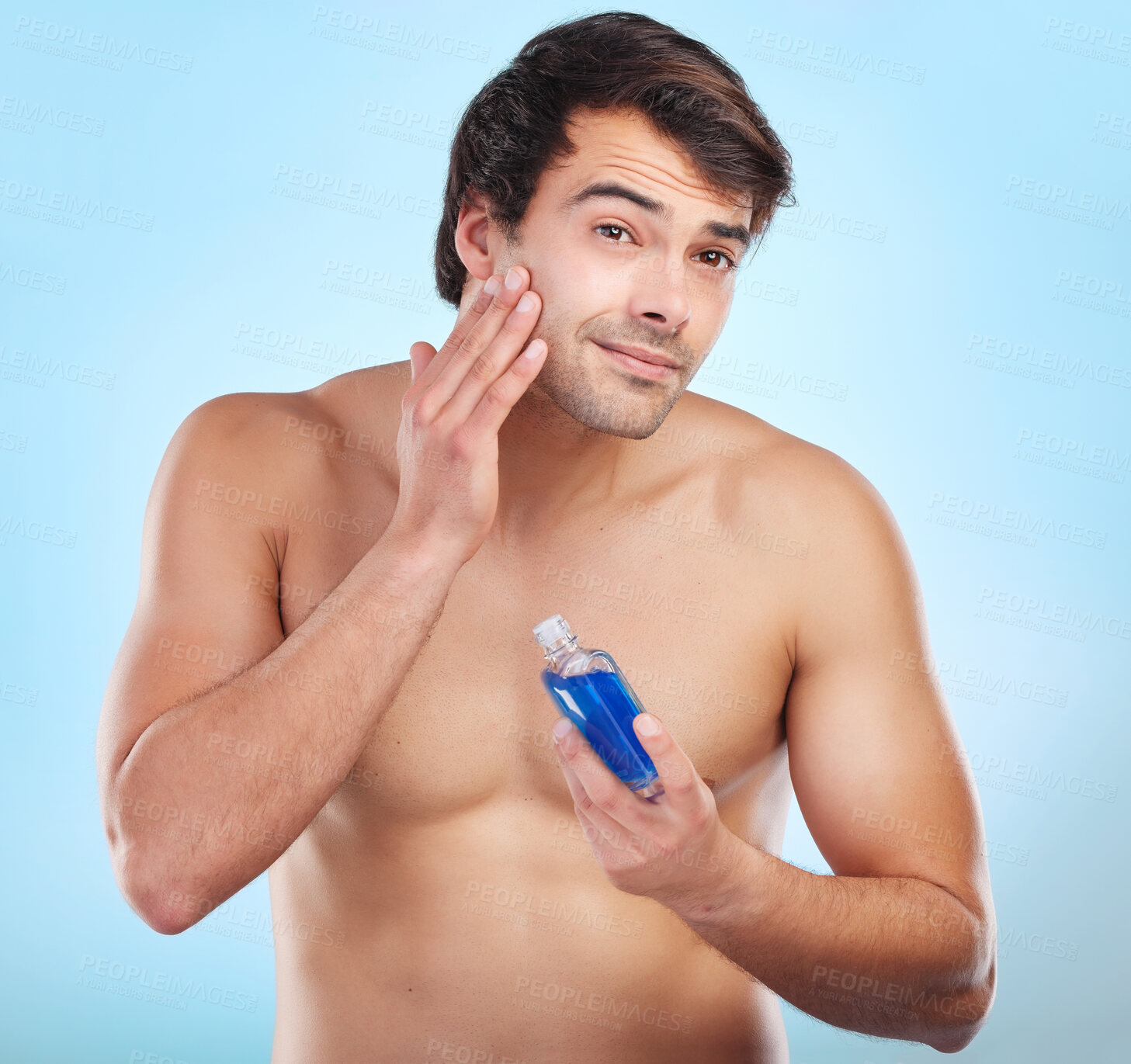 Buy stock photo Skincare, portrait and bottle product in studio with natural cosmetics for dermatology routine in morning for clear soft skin. Person, blue background and aftershave for grooming, hygiene and fresh.