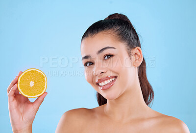 Buy stock photo Girl, portrait and orange in studio for skincare with healthy diet, beauty or hydration for skin glow. Woman, face and smile with vitamin c fruit for natural cosmetics and wellness on blue background