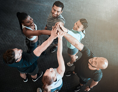 Buy stock photo Shot of a group of friends high fiving one another at the gym