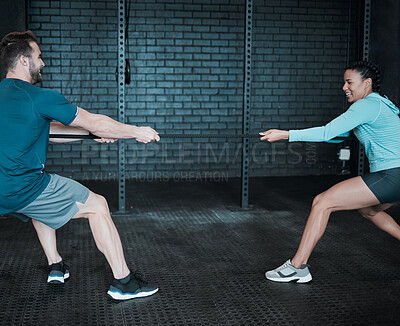 Buy stock photo Shot of two people pulling on a rope in tug of war at the gym