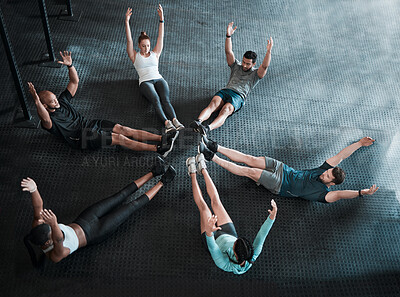 Buy stock photo Shot of a group of workout partners completing crunches together
