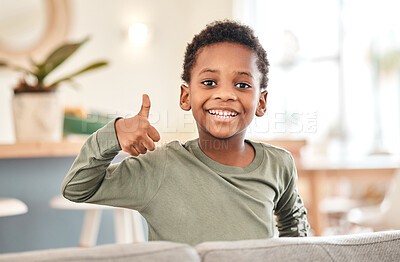 Buy stock photo Portrait of an adorable little boy showing thumbs up on the sofa at home