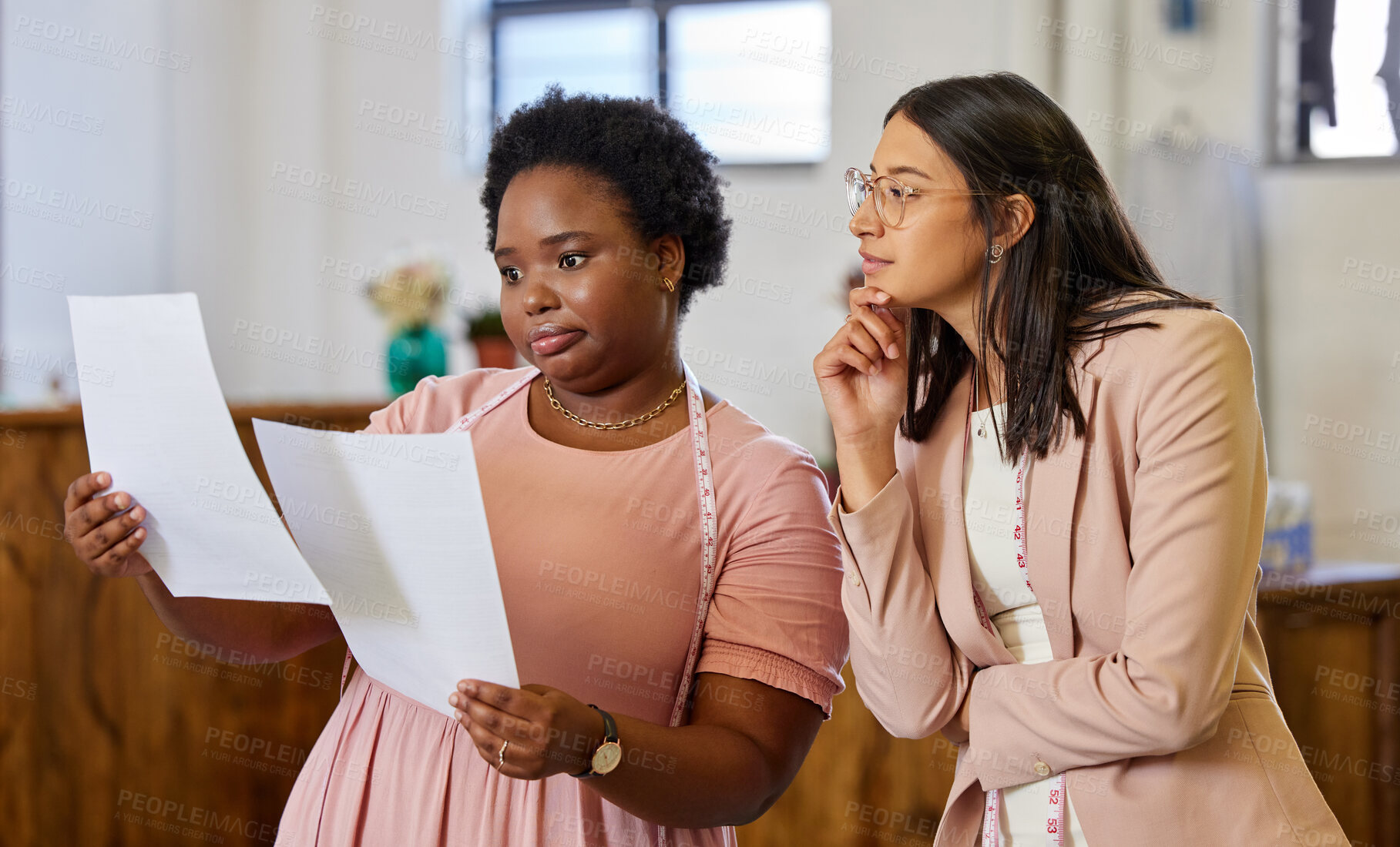 Buy stock photo Planning, woman colleagues and talking with thinking, tape and fashion designer in workspace. Pensive, communication and teamwork for coworkers and office, pattern or tailor with small business owner