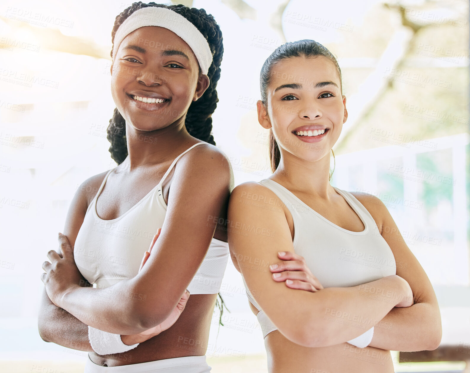 Buy stock photo Cropped portrait of two attractive young female tennis players standing with their arms folded in the clubhouse