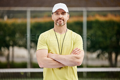 Buy stock photo Cropped portrait of a handsome mature male tennis coach standing with his arms folded on the court
