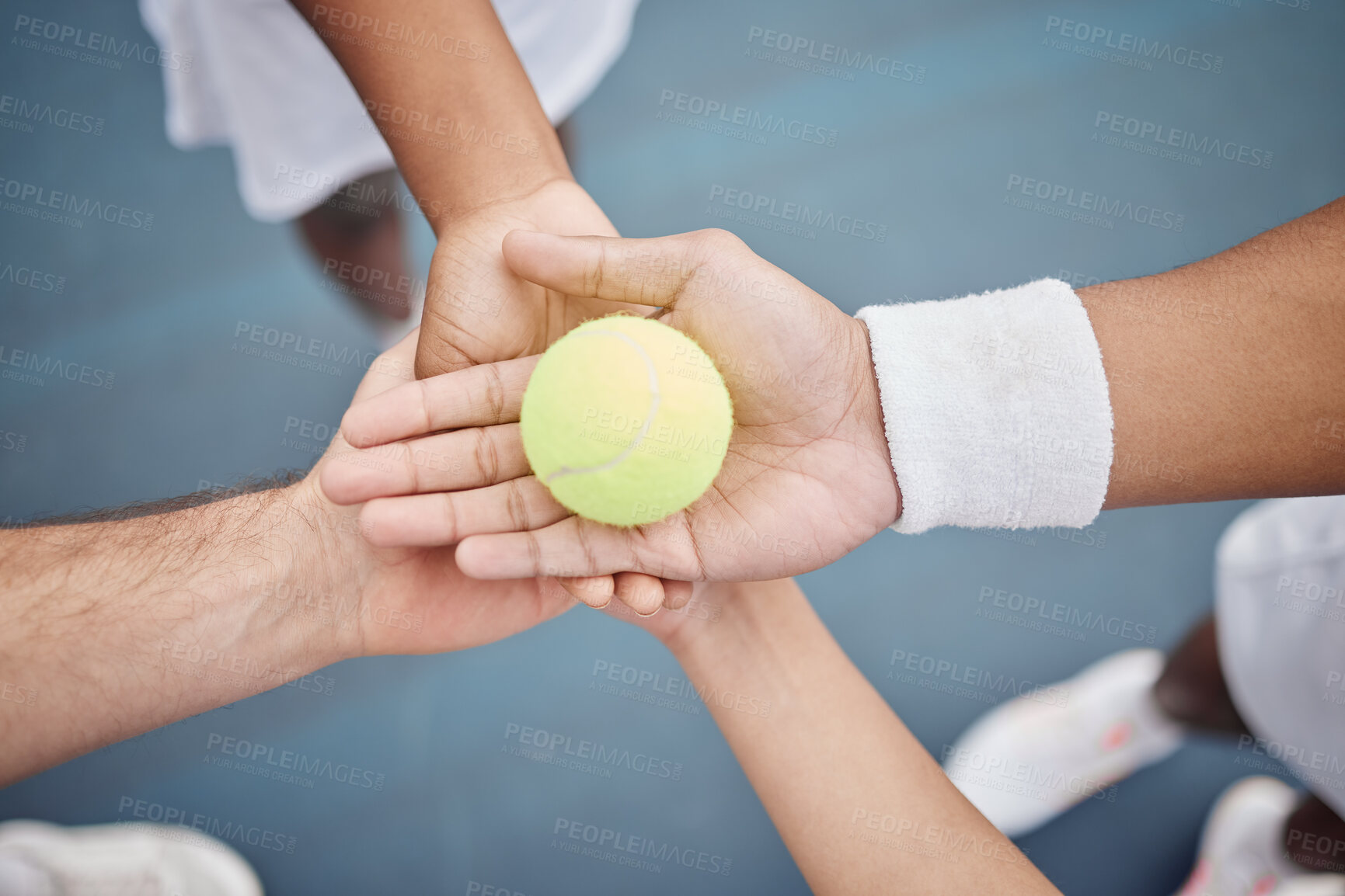 Buy stock photo High angle shot of four unrecognizable tennis players standing in a huddle with a ball on the court