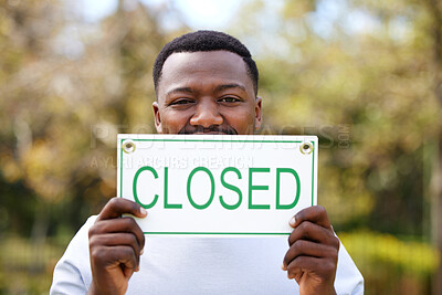 Buy stock photo Black man, portrait and nature with closed sign for out of business, debt or financial crisis. Young African or male person with billboard, poster or message for bankruptcy, announcement or alert