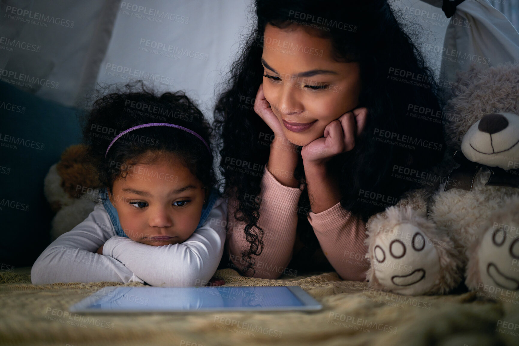 Buy stock photo Mother, girl and watching movie on tablet at night, fort and teddy bear for support. Mom, daughter and online subscription for streaming cartoon series, internet video and entertainment to relax