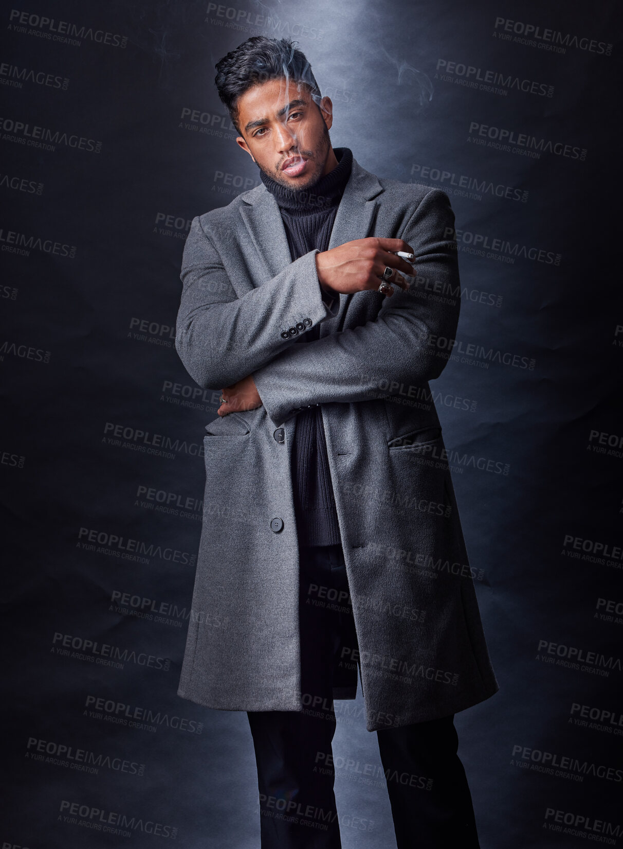 Buy stock photo Fashion, man smoking and dark studio with serious mafia leader, holding cigarette and cool stylish winter coat. Mysterious, trendy and edgy smoke for Indian mob, black background and confident model