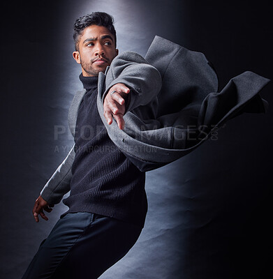 Buy stock photo Man, serious and fashion or dark studio, spy and coat with wind for escape and looking. Classy, semi formal and outfit on black background, male model and Indian person with trendy winter clothes