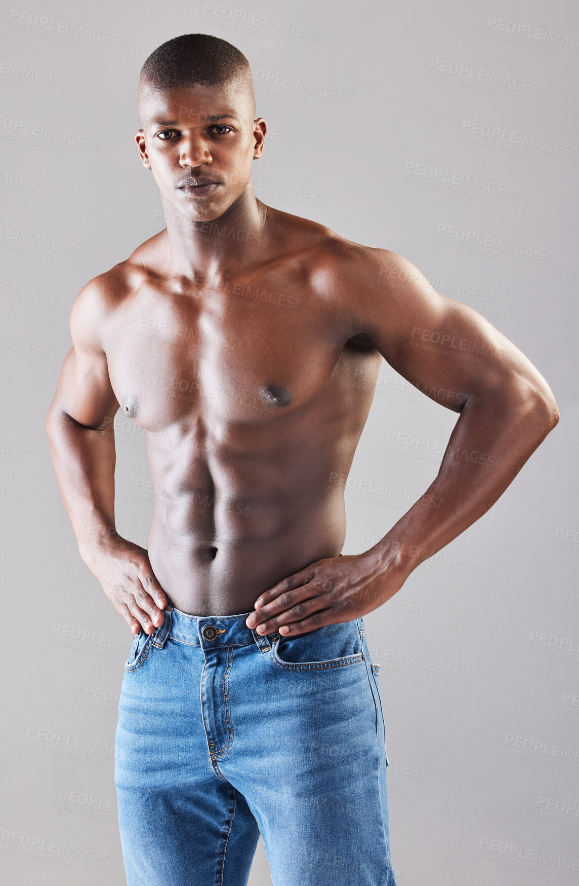 Buy stock photo Studio portrait of a muscular young man posing against a grey background