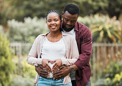 Buy stock photo Shot of a young expecting couple posing together in their yard
