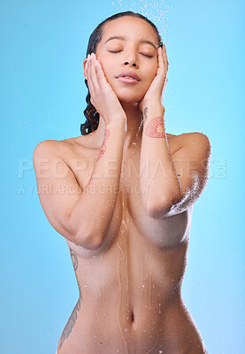 Buy stock photo Studio shot of an attractive young woman showering against a blue background