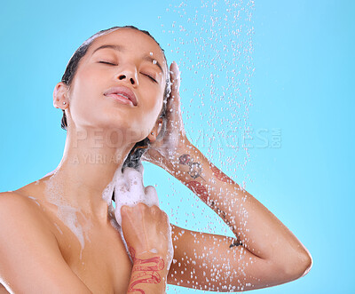 Buy stock photo Studio shot of an attractive young woman showering against a blue background