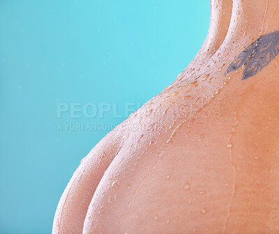 Buy stock photo Studio shot of an unrecognizable young woman showering against a blue background