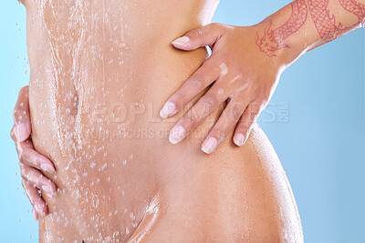 Buy stock photo Studio shot of an unrecognizable young woman showering against a blue background