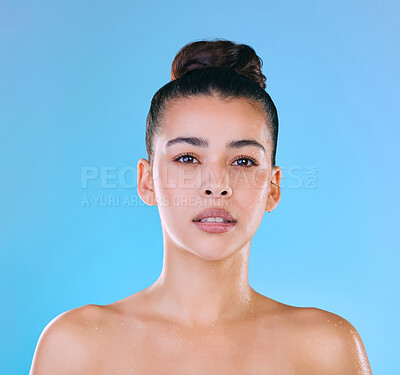 Buy stock photo Shot of a beautiful young woman being splashed with water against a blue background