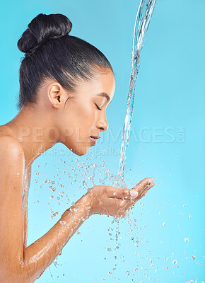 Buy stock photo Shot of an attractive young woman posing against a blue background while taking a shower