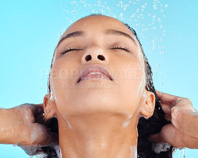 Buy stock photo Face, hair and shower by woman in studio for cleaning, wash and shampoo on blue background. Girl, haircare and model relax in water splash, hygiene and grooming, skincare and wellness isolated