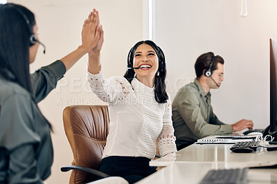 Buy stock photo Shot of a young call centre agent giving her colleague a high five in an office