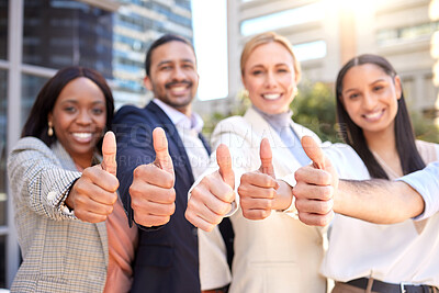 Buy stock photo Shot of a group of businesspeople showing a thumbs up against a city background