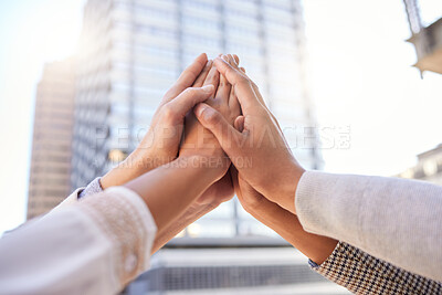 Buy stock photo Shot of a group of unrecognizable businesspeople giving each other a high five against a city background