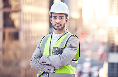 Buy stock photo Cropped portrait of a handsome male construction worker standing with his arms folded on a building site