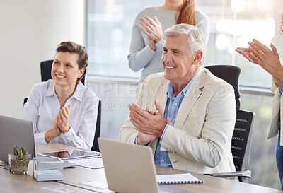 Buy stock photo Shot of a diverse group of businesspeople clapping and celebrating a success in the office