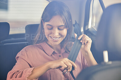Buy stock photo Shot of a young woman fastening her seatbelt in a car