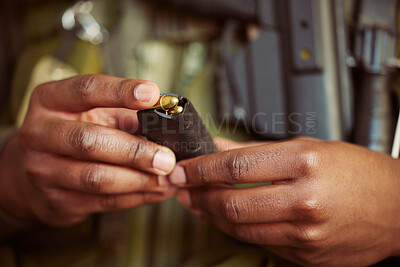 Buy stock photo Shot of an unrecognisable man loading a magazine cartridge with bullets