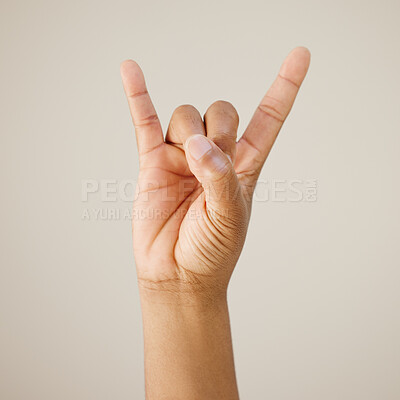 Buy stock photo Rock and roll, hands and person with icon in studio background for festival communication, punk sign and metal music. Devil horns, emoji and show rebel for opinion, funky concert and band aesthetic