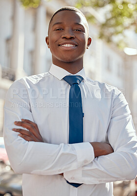 Buy stock photo Shot of a young businessman standing with his arms crossed in the city