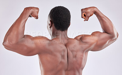 Buy stock photo Studio shot of muscular young man flexing his arms against a grey background